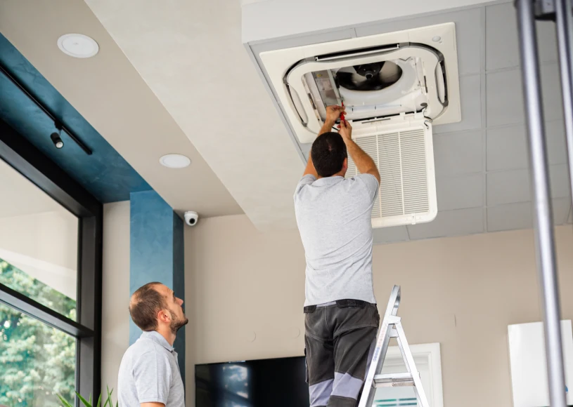 Technicians repairing ceiling air conditioning unit