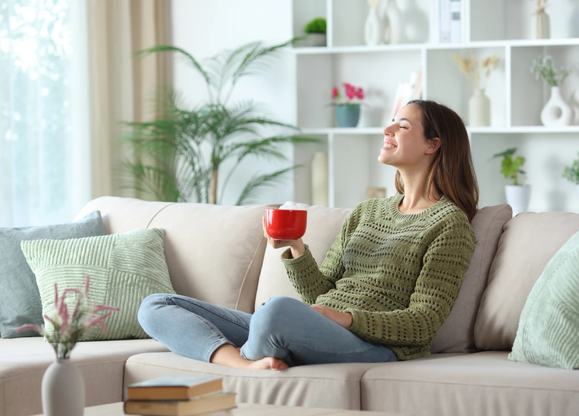 Woman relaxing with coffee on sofa