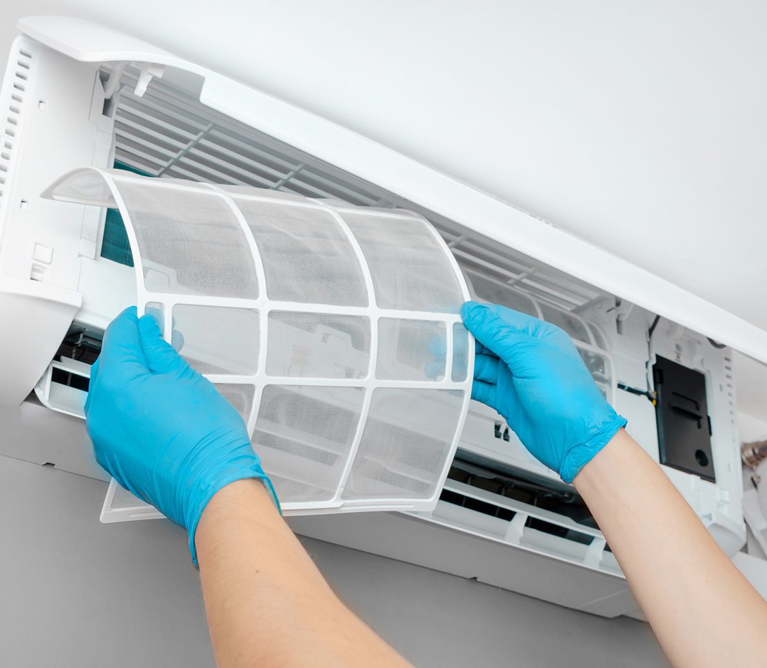 Cleaning air conditioner filter with gloves.