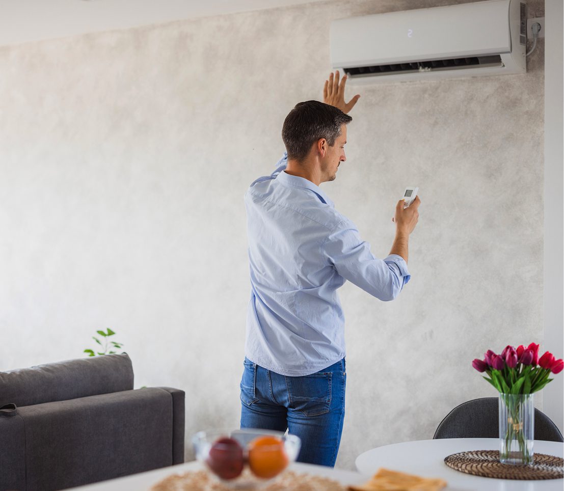 Person operating wall-mounted AC unit